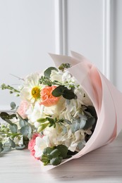 Bouquet of beautiful flowers on white wooden table, closeup