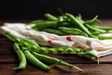 Photo of Fresh green beans on wooden table, closeup