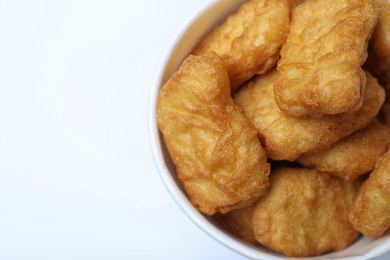 Photo of Bucket with tasty chicken nuggets on white background, top view