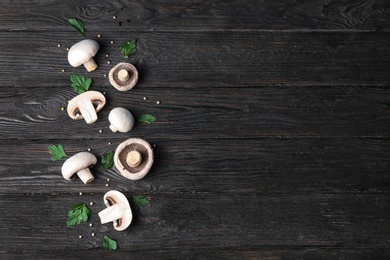 Photo of Flat lay composition with fresh champignon mushrooms on wooden background, space for text