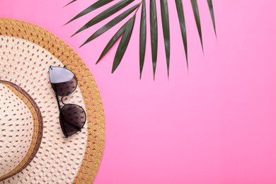 Photo of Straw hat, stylish sunglasses and palm leaf on pink background, flat lay with space for text. Beach accessories