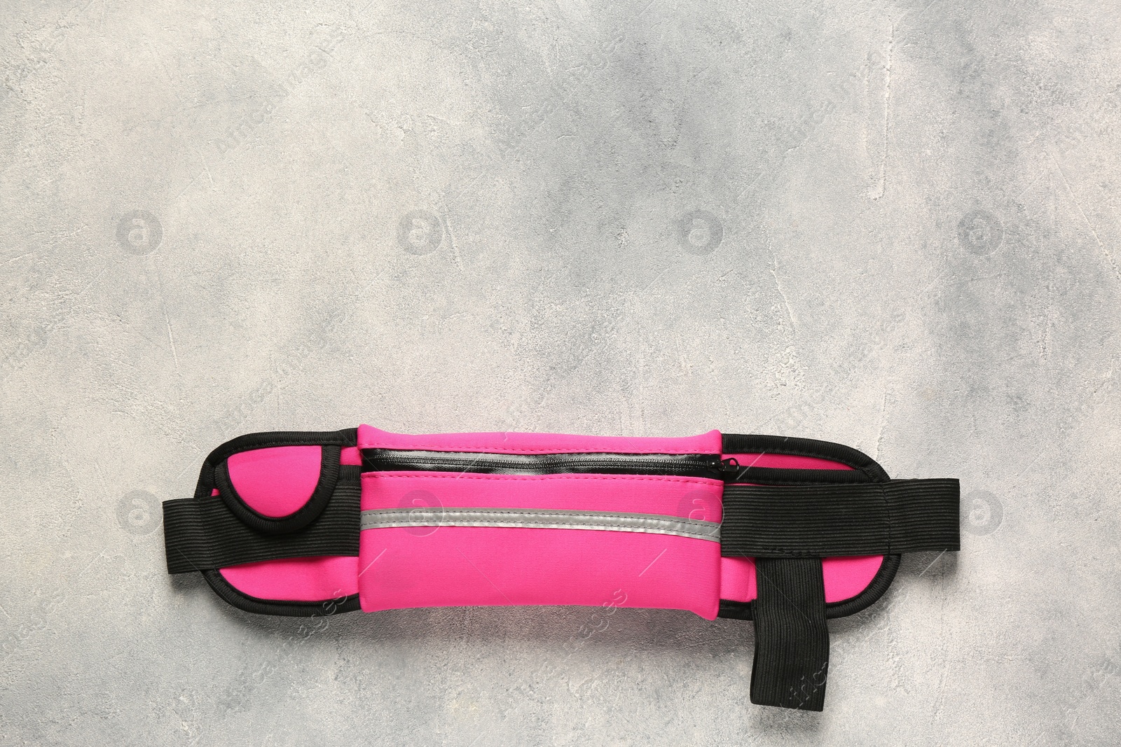 Photo of Stylish pink waist bag on light grey table, top view. Space for text