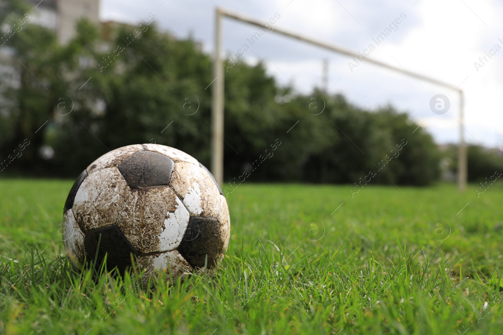 Photo of Dirty soccer ball on green grass outdoors, space for text