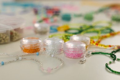 Photo of Beautiful handmade beaded jewelry and supplies on white table