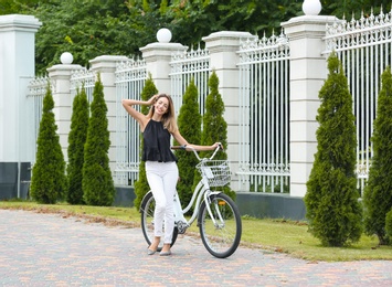 Beautiful woman in casual outfit with bicycle on city street