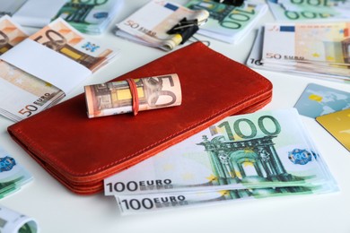 Photo of Wallet, different Euro banknotes and credit cards on white table, closeup. Money exchange