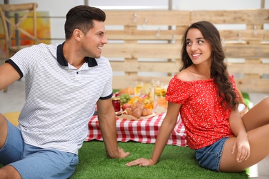 Photo of Happy lovely couple imitating picnic at home