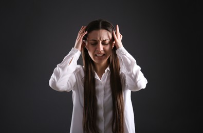 Portrait of emotional young woman on black background. Personality concept