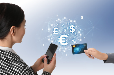 Image of Fintech concept. Woman using phone to make financial transactions with credit card