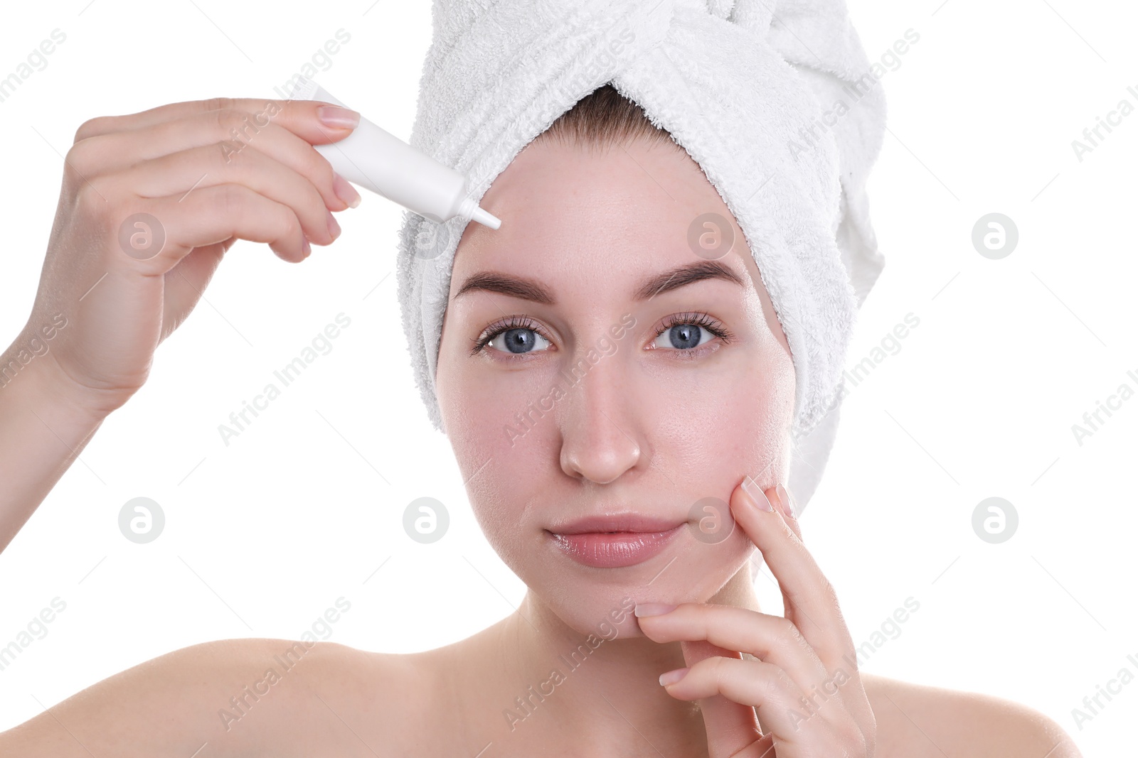 Photo of Young woman with acne problem applying cosmetic product onto her skin on white background