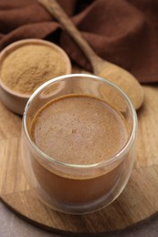 Soluble fiber with water in glass, powder and spoon on table, closeup