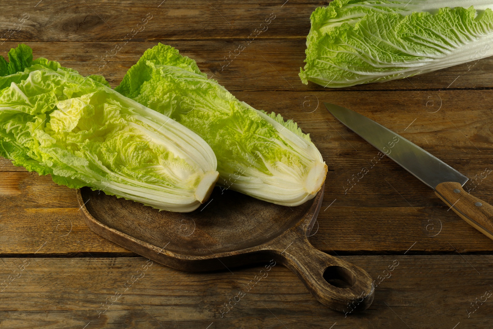 Photo of Cut fresh ripe Chinese cabbage on wooden table