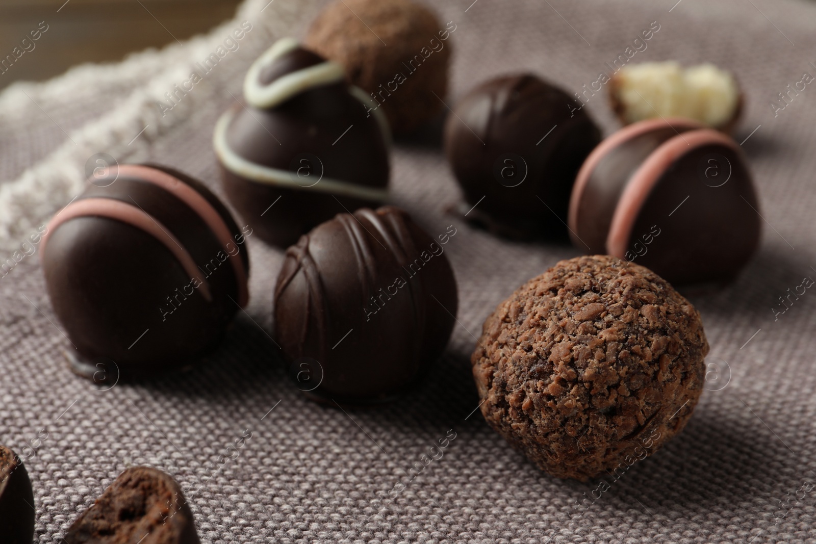 Photo of Many different delicious chocolate truffles on kitchen towel