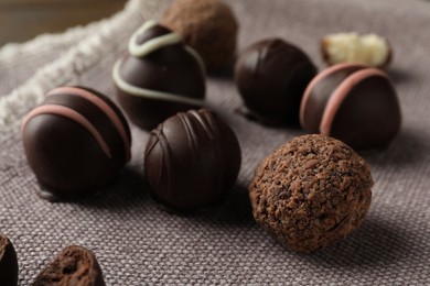 Photo of Many different delicious chocolate truffles on kitchen towel