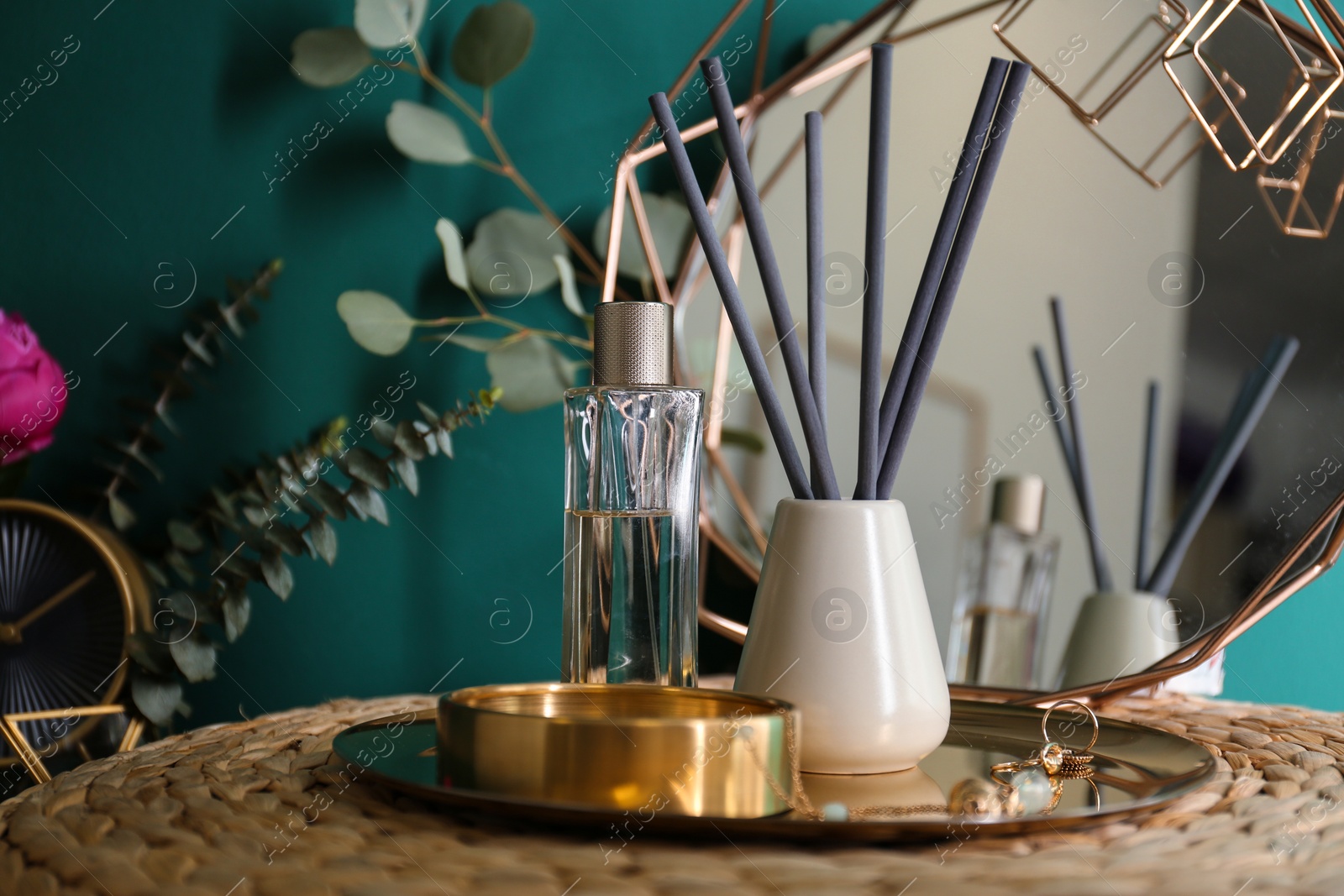 Photo of Composition with stylish accessories and interior elements on table near turquoise wall