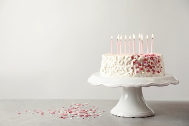 Photo of Birthday cake with candles on table against light background