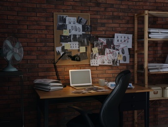 Photo of Workplace with laptop and detective board in office