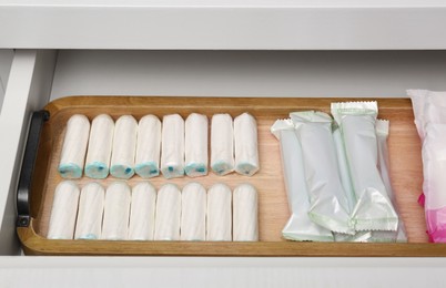 Storage of many different tampons in white drawer. Menstrual hygienic product