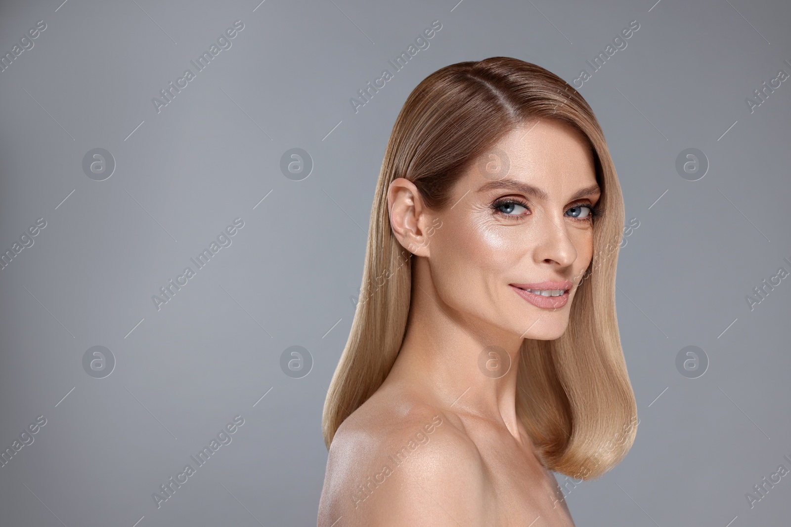 Image of Portrait of attractive woman with blonde hair on grey background, space for text