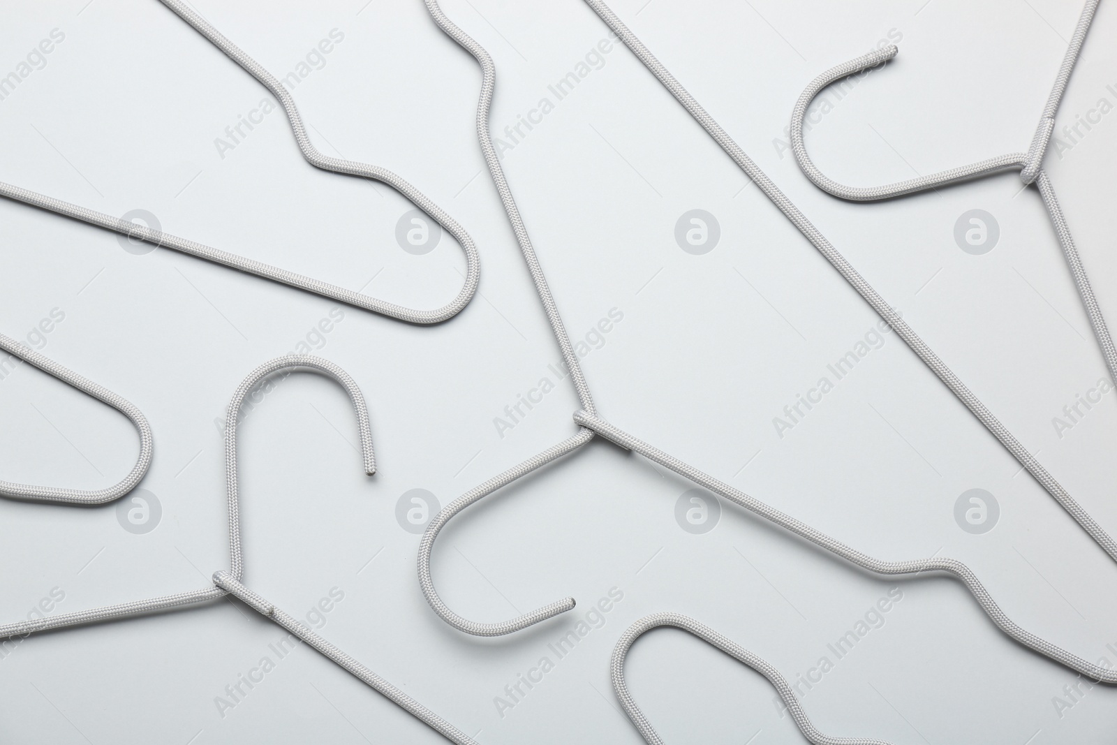 Photo of Hangers on light gray background, flat lay
