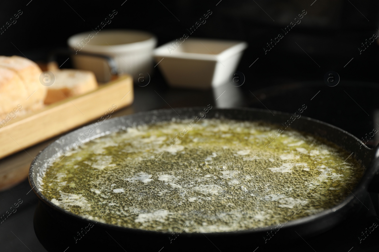 Photo of Melted butter in frying pan on table, closeup