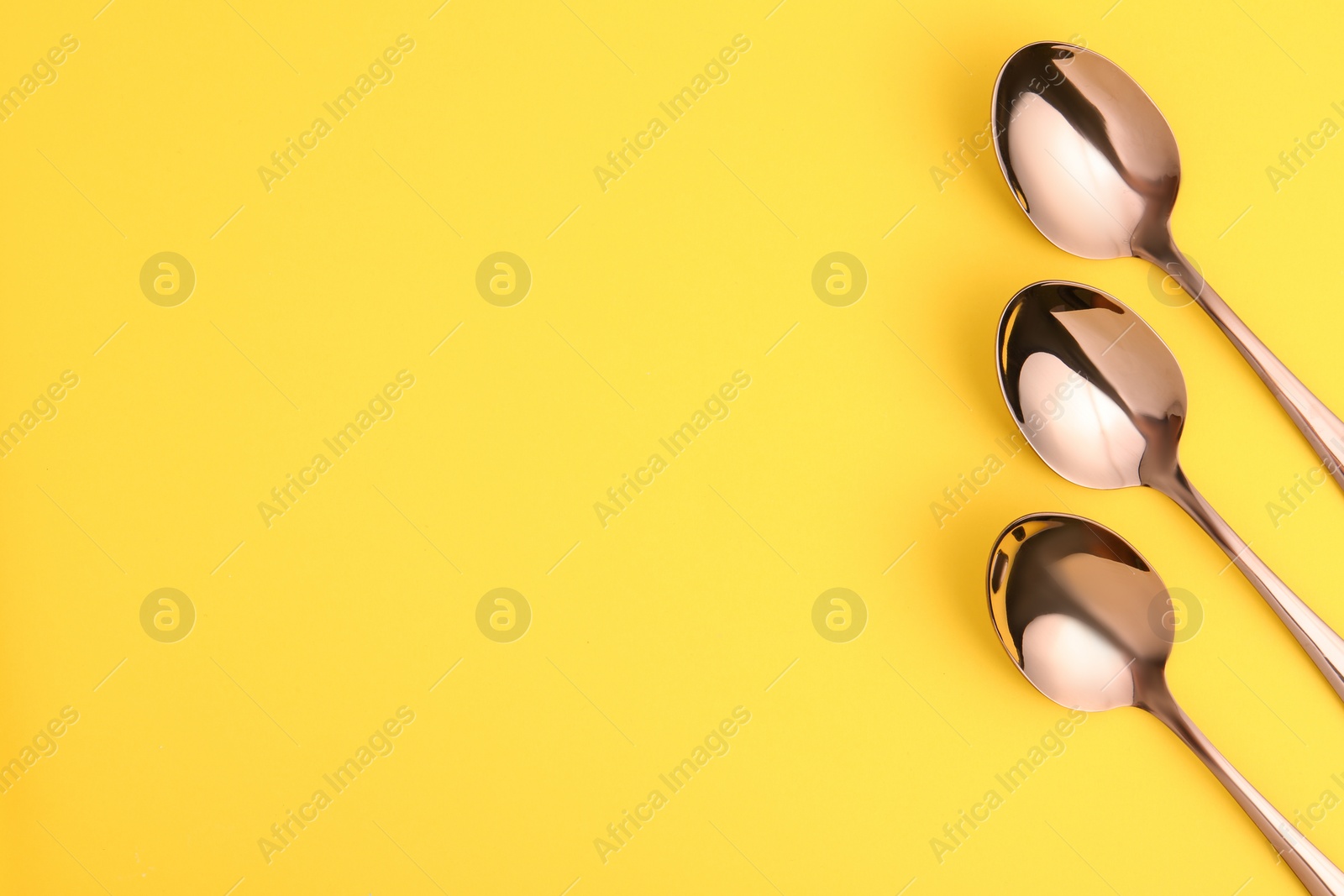 Photo of Flat lay composition with clean tea spoons and space for text on color background