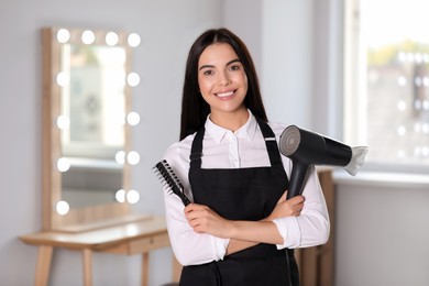 Photo of Portrait of happy hairdresser with professional tools in beauty salon