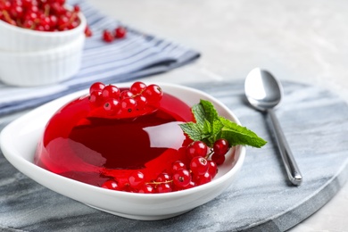 Photo of Delicious jelly with berries and mint on table