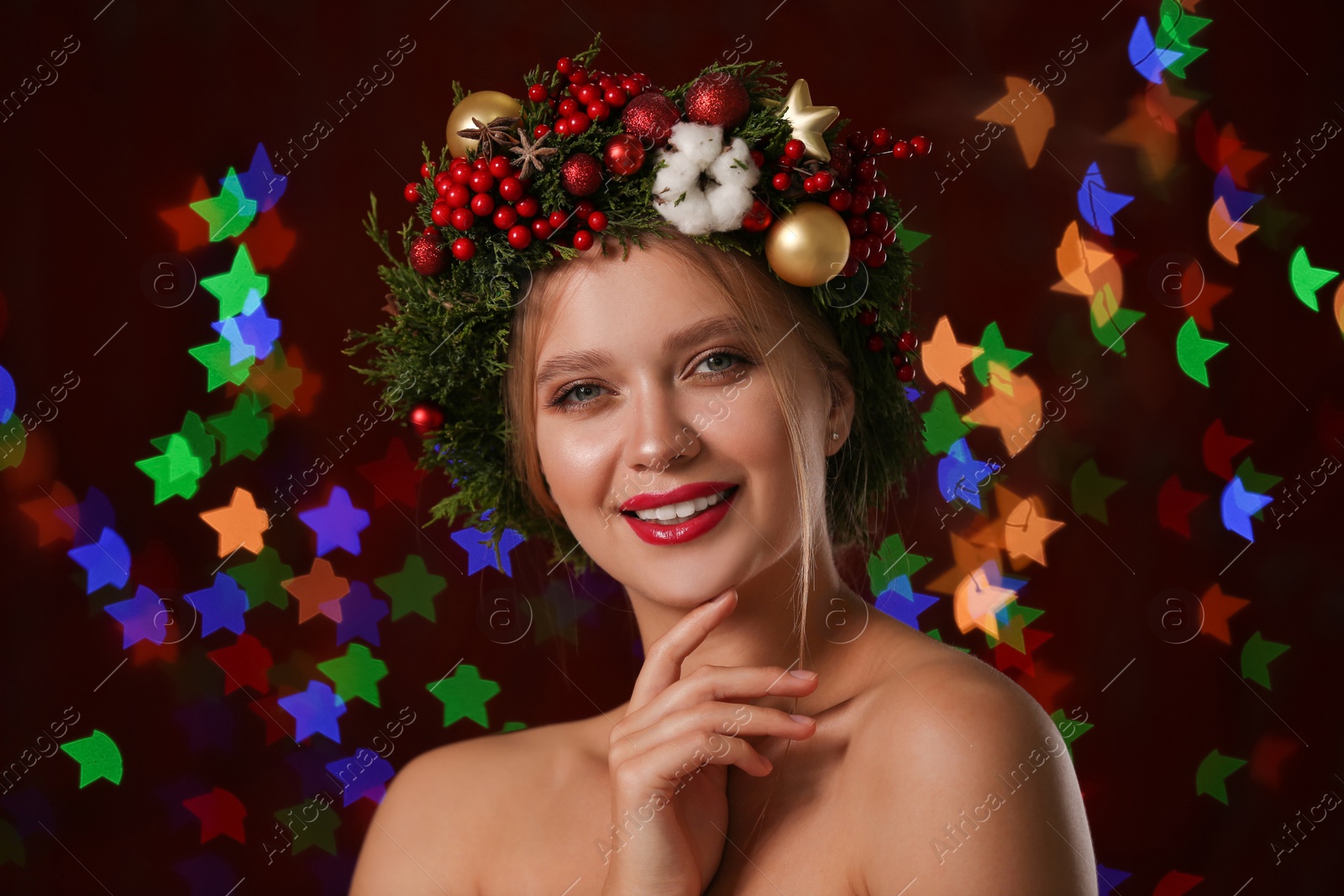 Photo of Beautiful young woman wearing Christmas wreath on blurred background. Bokeh effect