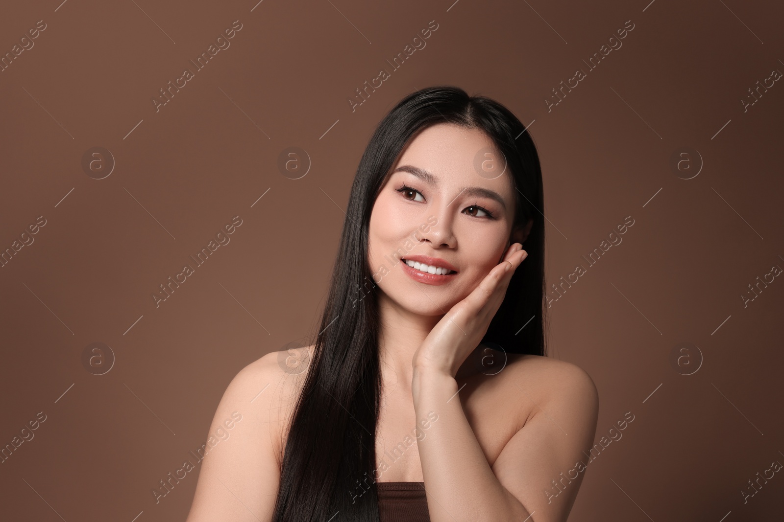 Photo of Portrait of beautiful woman on brown background