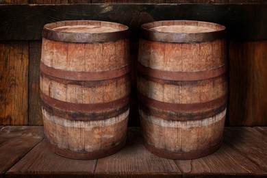 Image of Wooden barrels on brown shelf near textured wall