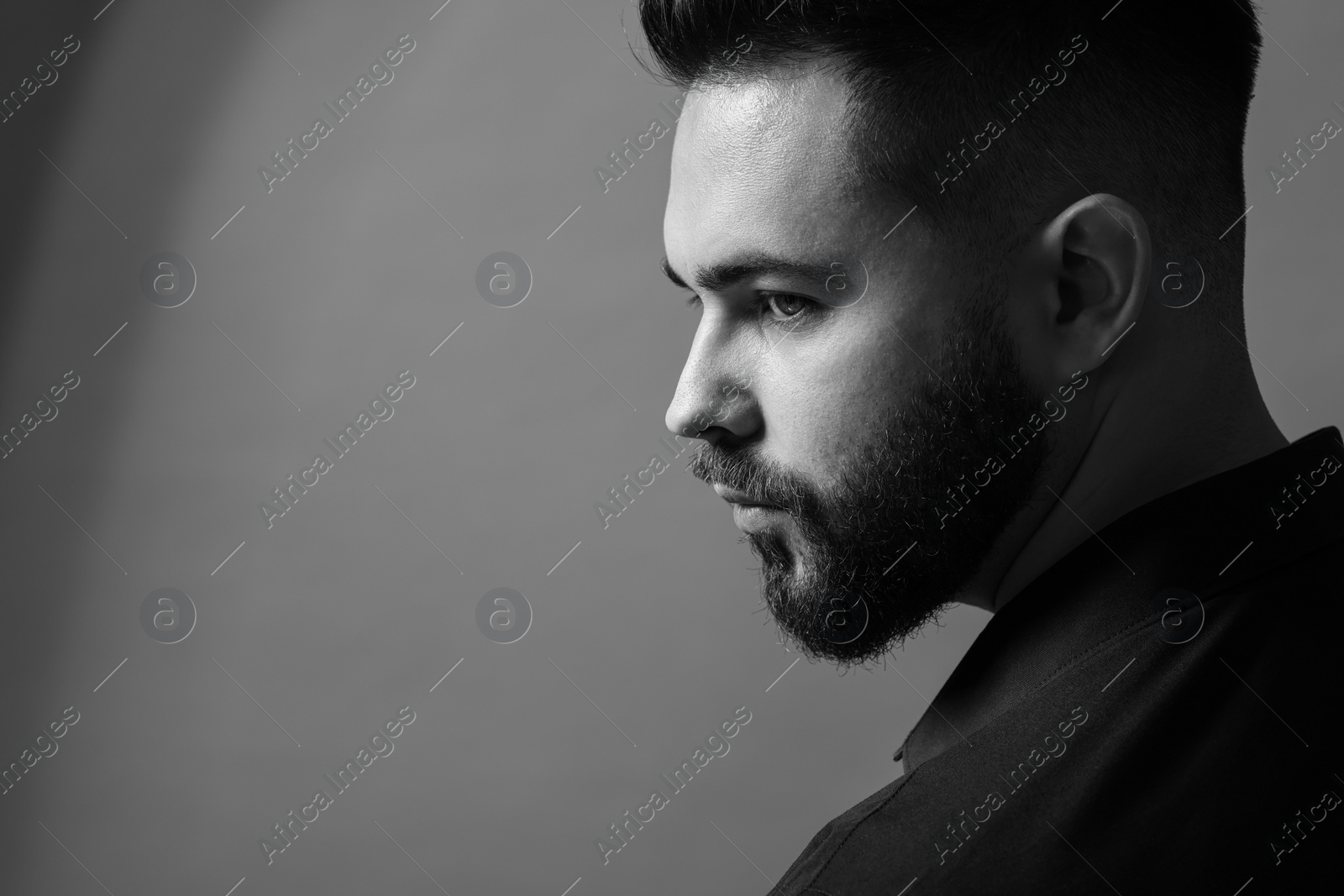 Photo of Portrait of handsome bearded man on grey background, space for text. Black and white effect