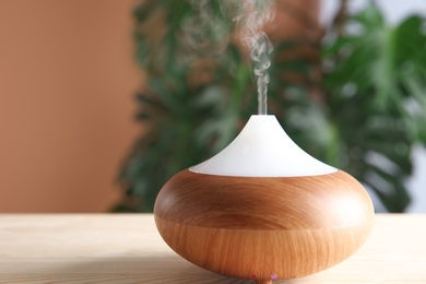 Photo of Aroma oil diffuser on table indoors