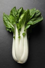 Photo of Fresh green pak choy cabbage on black table, top view