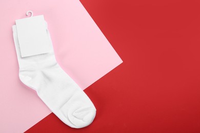 Photo of Pair of white cotton socks on color background, top view. Space for text