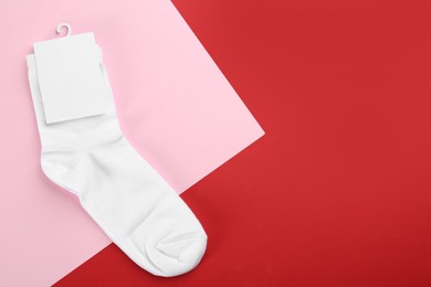 Pair of white cotton socks on color background, top view. Space for text