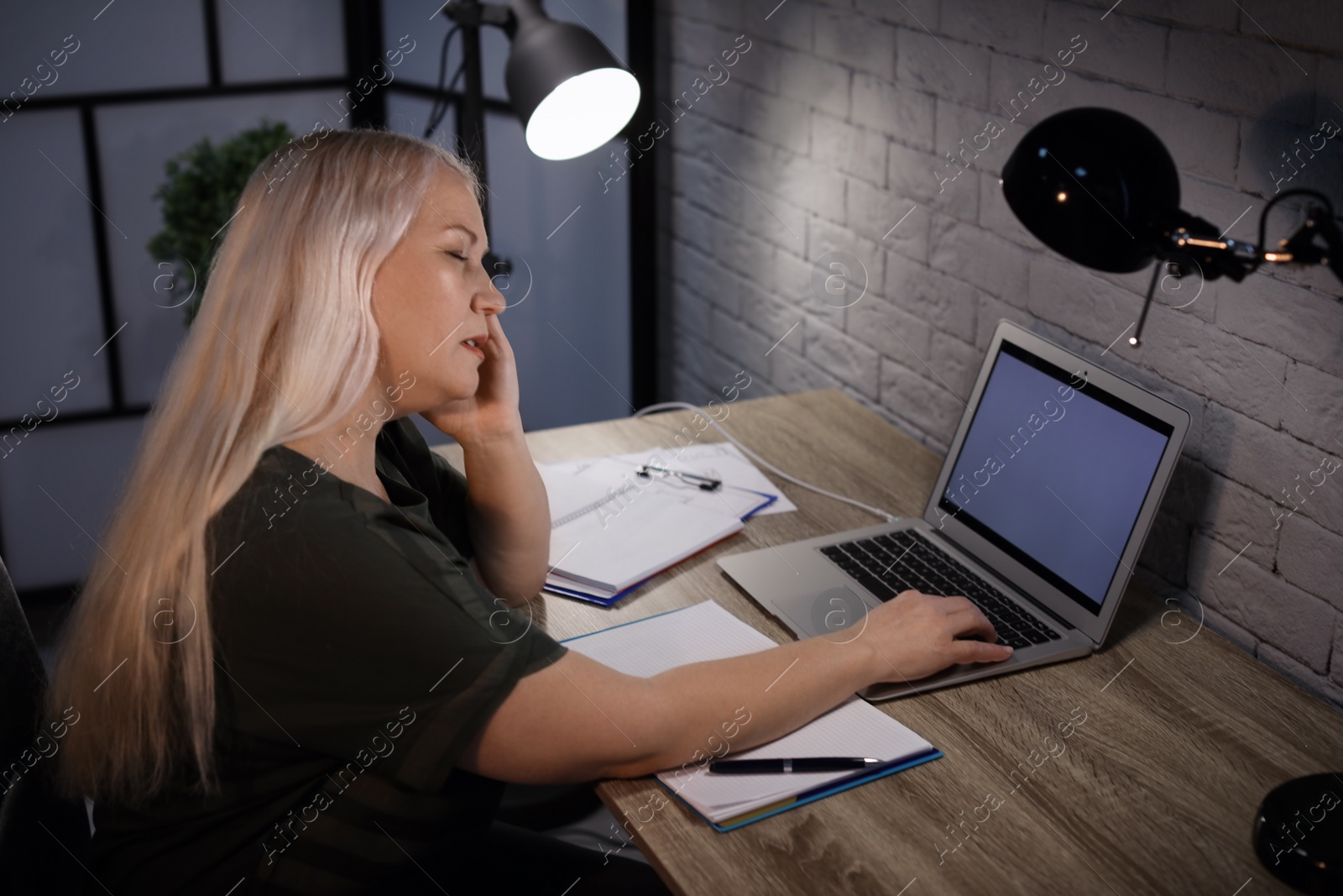 Photo of Overworked mature woman with headache in office