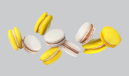 Image of Sweet delicious macarons flying on grey background