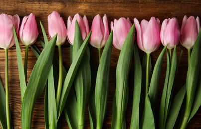 Beautiful pink spring tulips on wooden background, flat lay