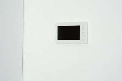 Photo of Modern video intercom hanging on white wall