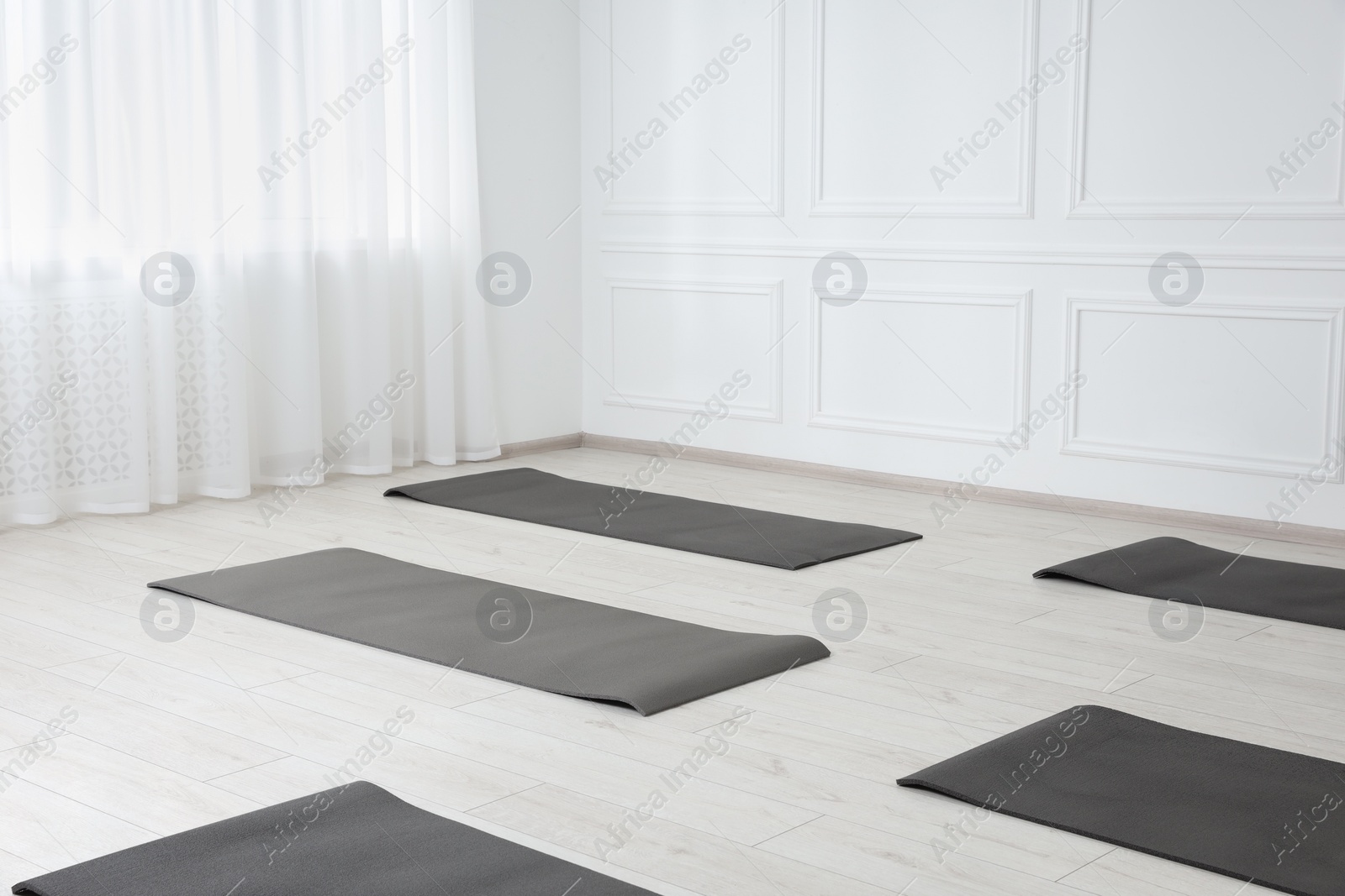 Photo of Spacious yoga studio with exercise mats. Space for text