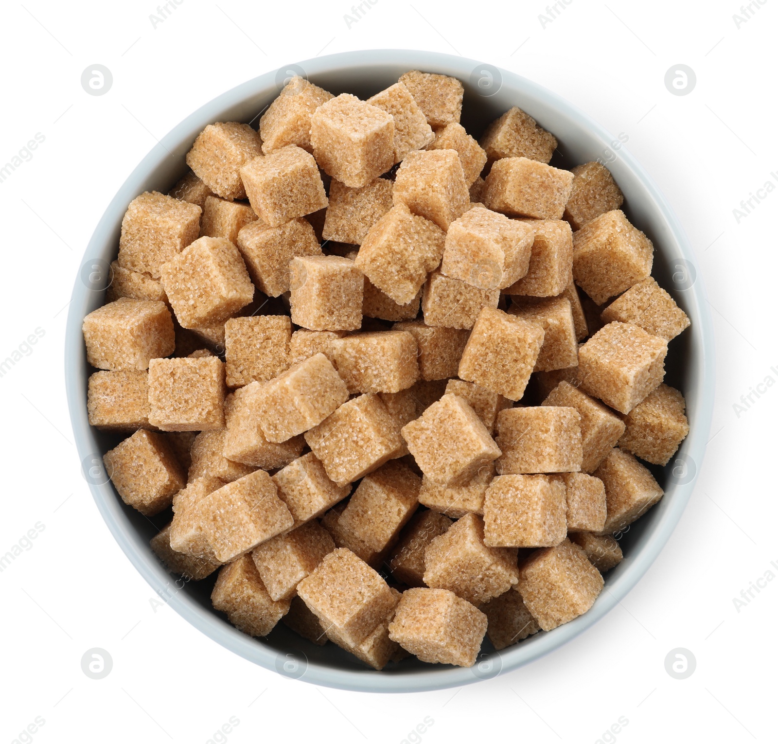 Photo of Bowl and brown sugar cubes on white background, top view