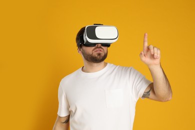 Photo of Man using virtual reality headset on yellow background