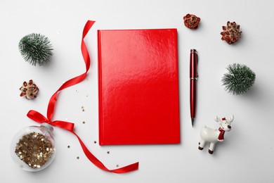 Photo of Red planner and Christmas decor on white background, flat lay. New Year aims