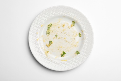 Photo of Dirty plate with food leftovers on white background, top view