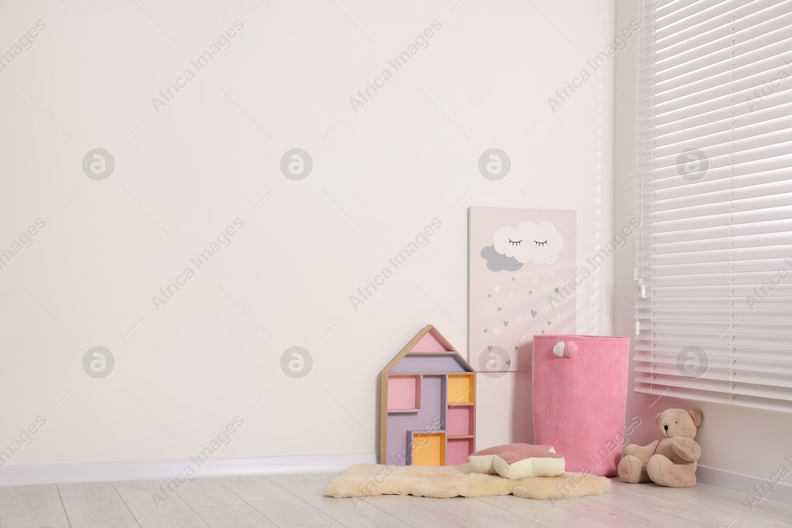 Photo of Beautiful children's room with light wall and toys, space for text. Interior design