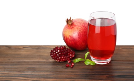 Photo of Refreshing pomegranate juice in glass, leaves and fruits on wooden table against white background. Space for text