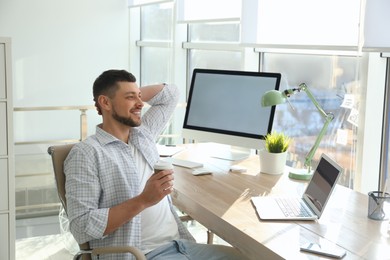 Photo of Freelancer with cup of coffee resting from work indoors