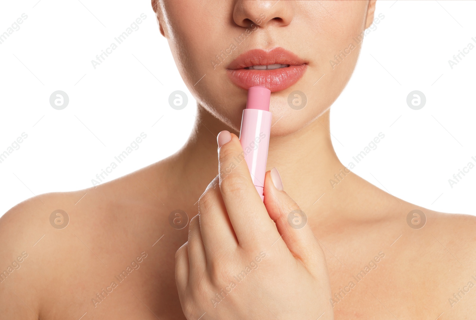 Photo of Young woman applying lip balm on white background, closeup