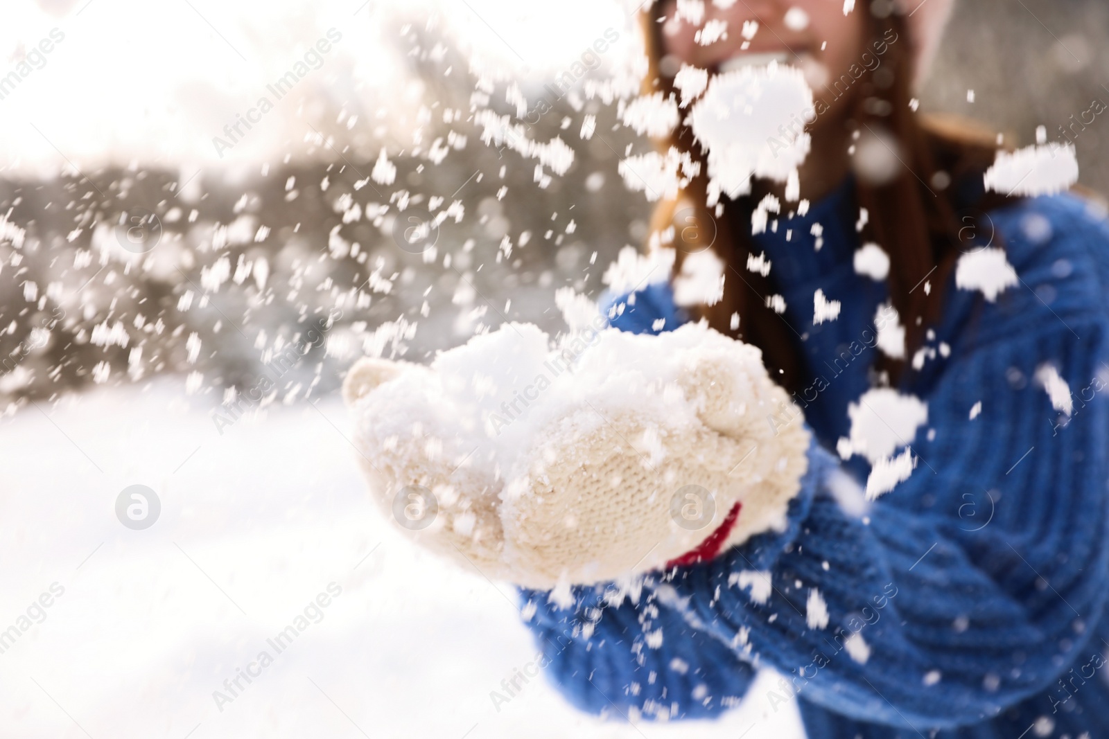 Photo of Young woman playing with snow outdoors, closeup. Winter vacation